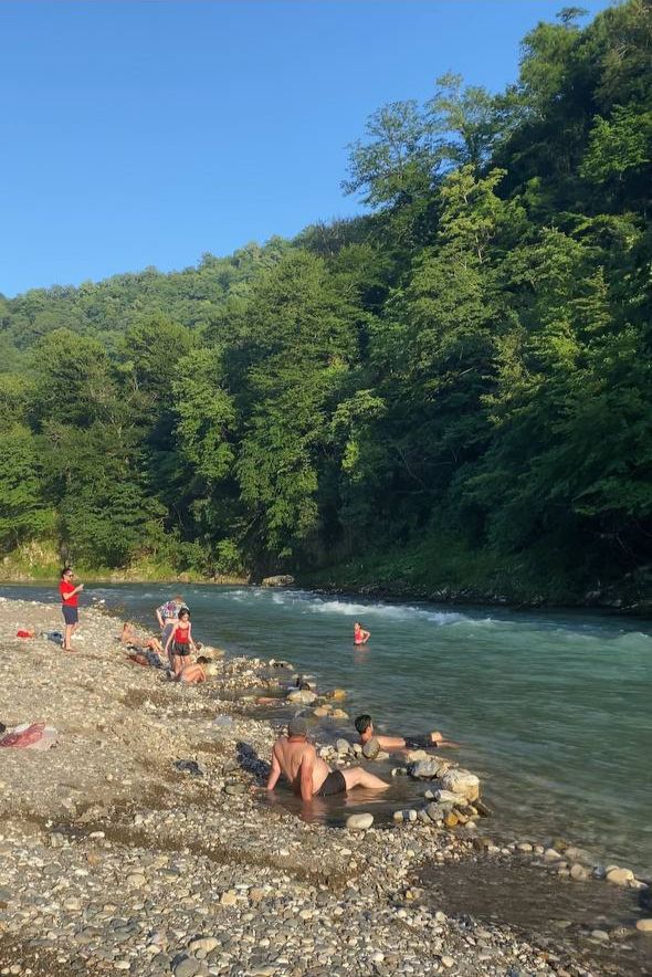 Люди примают термальные ванны на берегу реки Техура у источника Нокалакеви